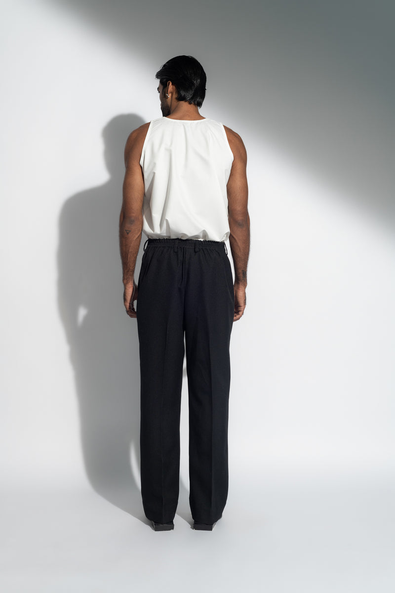 ROSANI The Ankathi trouser in black - relaxed wide-leg tailored trousers with front pleats and elastic back waistband, back view, styled with a white top