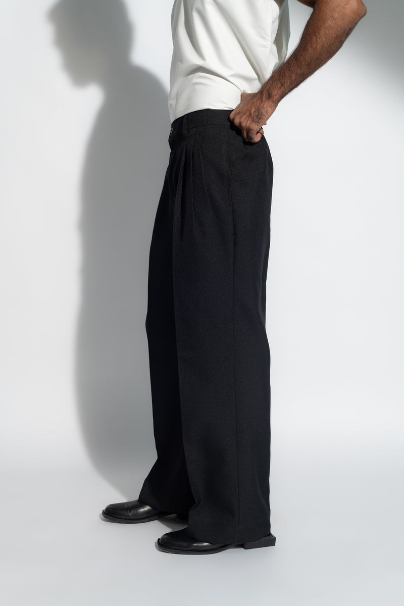 ROSANI The Ankathi trouser in black - relaxed wide-leg tailored trousers with front pleats and elastic back waistband, side view, styled with a white top