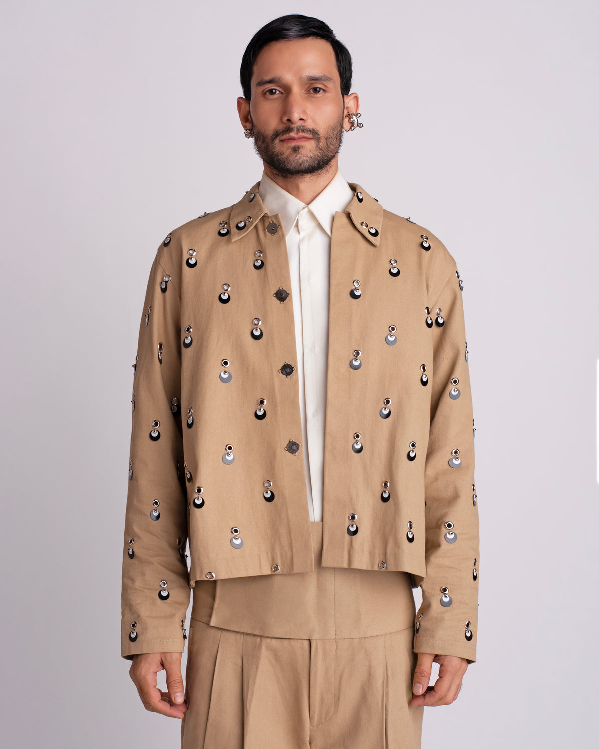 ROSANI The Carter jacket in khaki. Relaxed fit jacket with metallic eyelets, magnetic button accents and overlapping sequin detail. ANIMA and ANIMUS collection, front view.