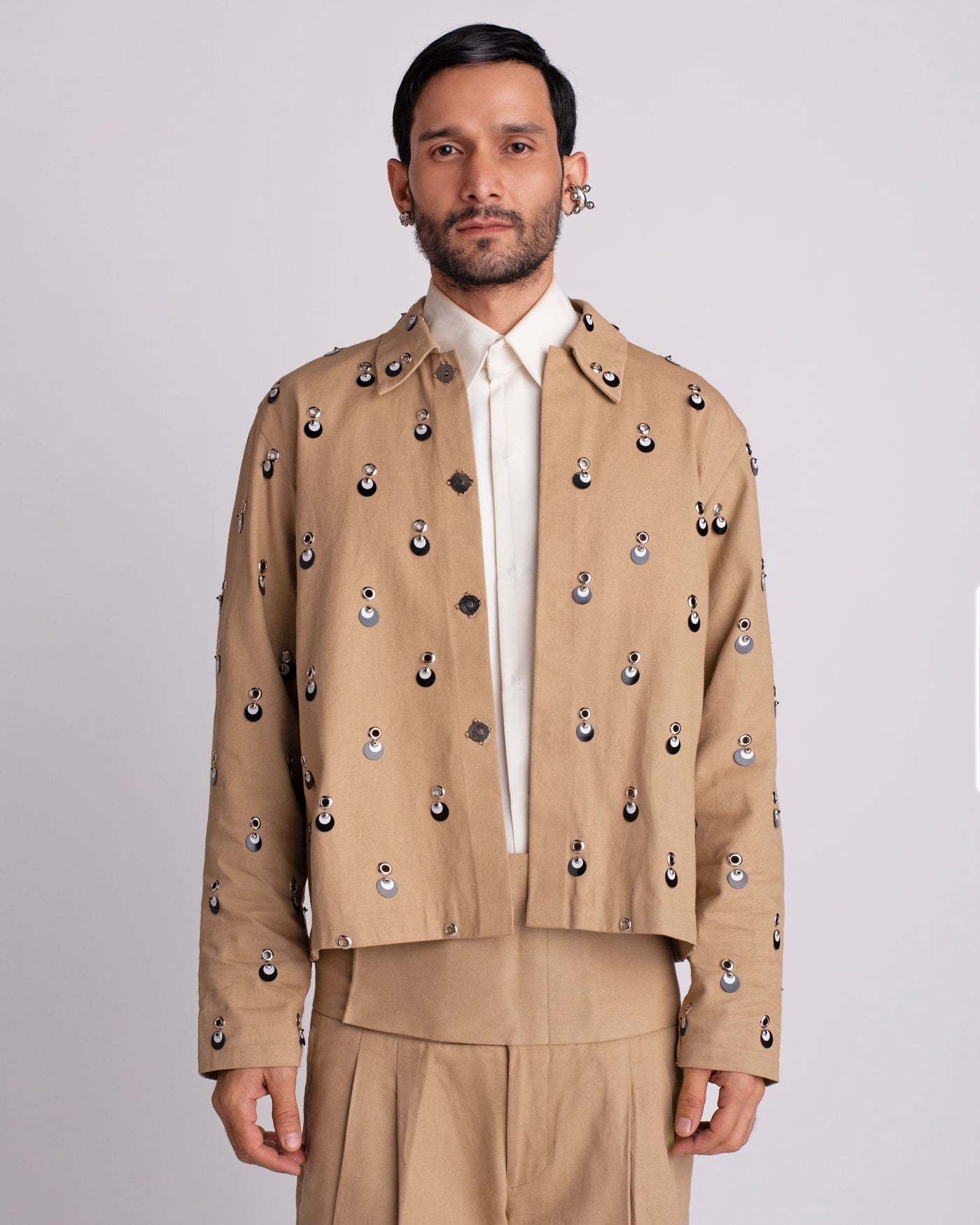 ROSANI The Carter jacket in khaki. Relaxed fit jacket with metallic eyelets, magnetic button accents and overlapping sequin detail. ANIMA and ANIMUS collection, front view.
