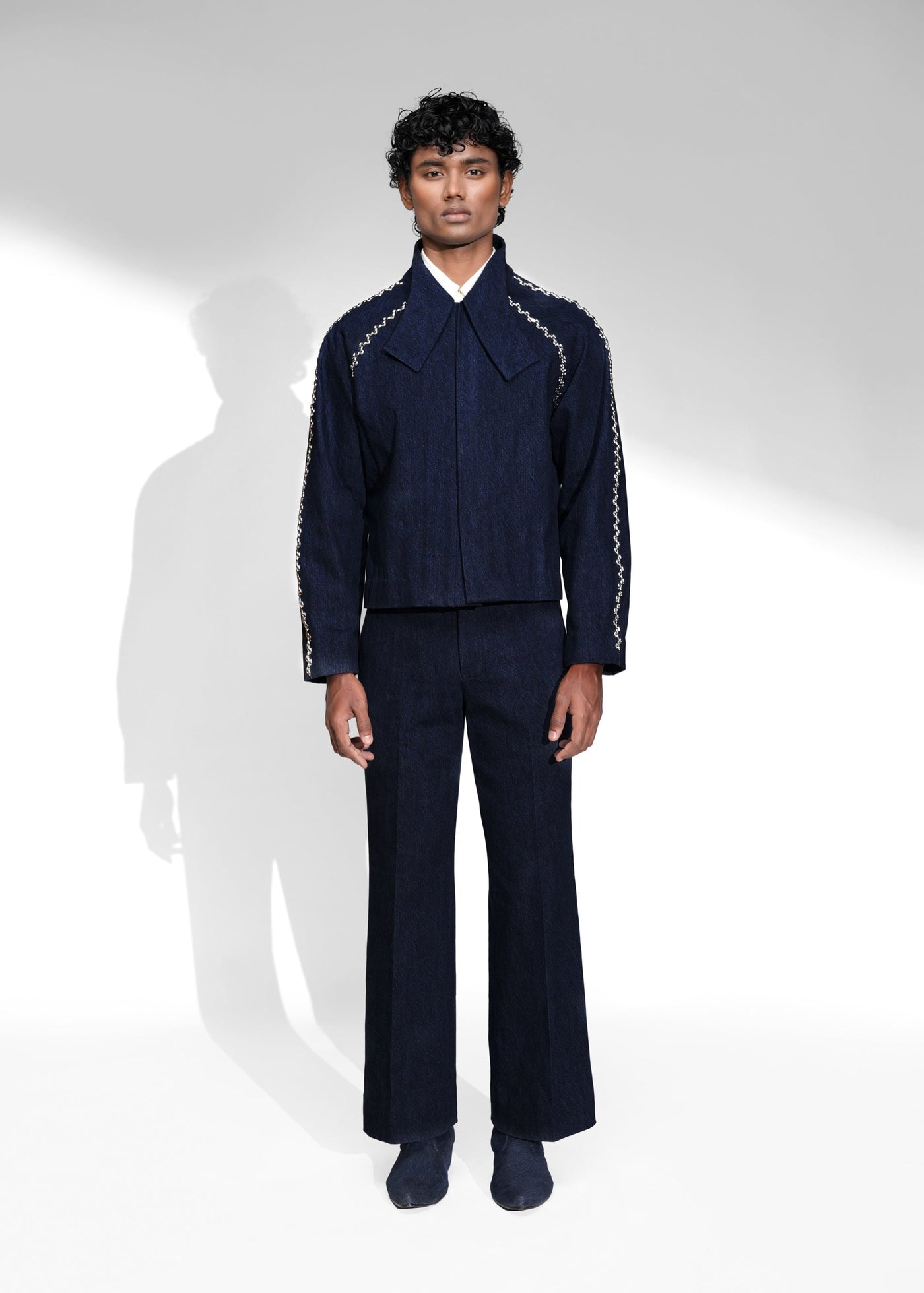 ROSANI The Cloister jacket in midnight denim - cropped raglan-sleeve jacket with metallic seam accents, front view