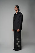 ROSANI The Column blazer in black - sharp-shouldered tailored blazer with wrap front and clean peak lapel, styled with The Eden trouser, front side view