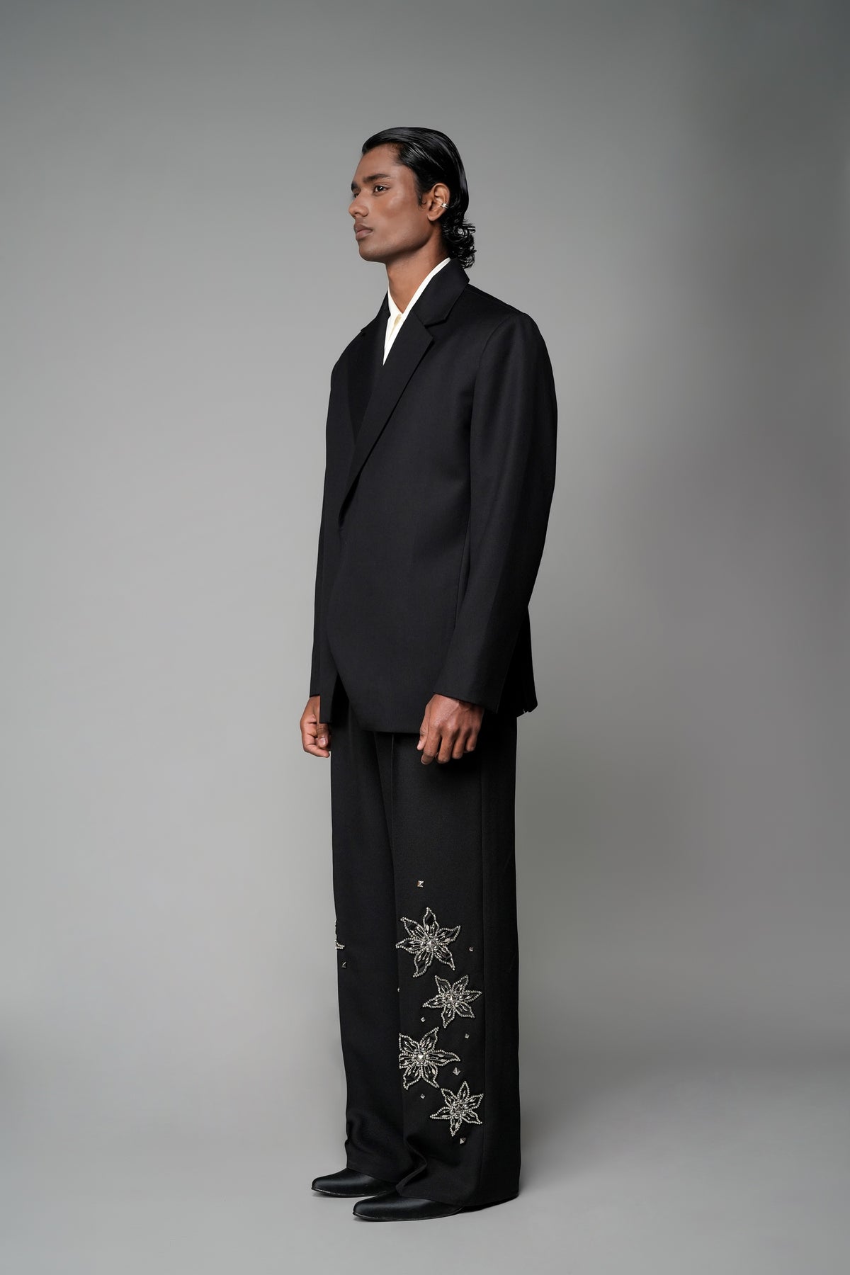 ROSANI The Column blazer in black - sharp-shouldered tailored blazer with wrap front and clean peak lapel, styled with The Eden trouser, front side view