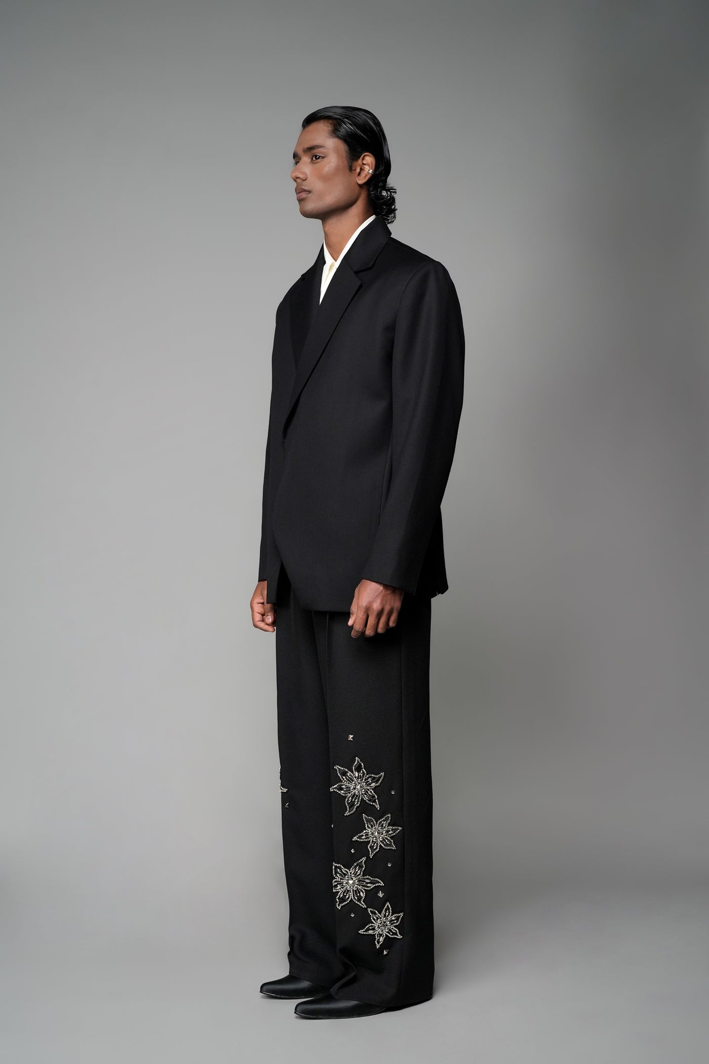 ROSANI The Column blazer in black - sharp-shouldered tailored blazer with wrap front and clean peak lapel, styled with The Eden trouser, front side view