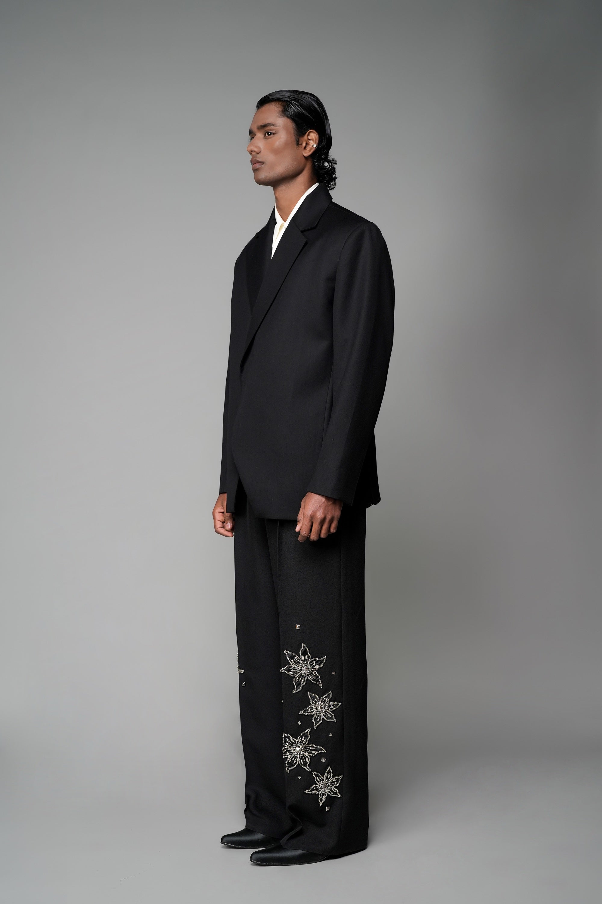 ROSANI The Column blazer in black - sharp-shouldered tailored blazer with wrap front and clean peak lapel, styled with The Eden trouser, front side view