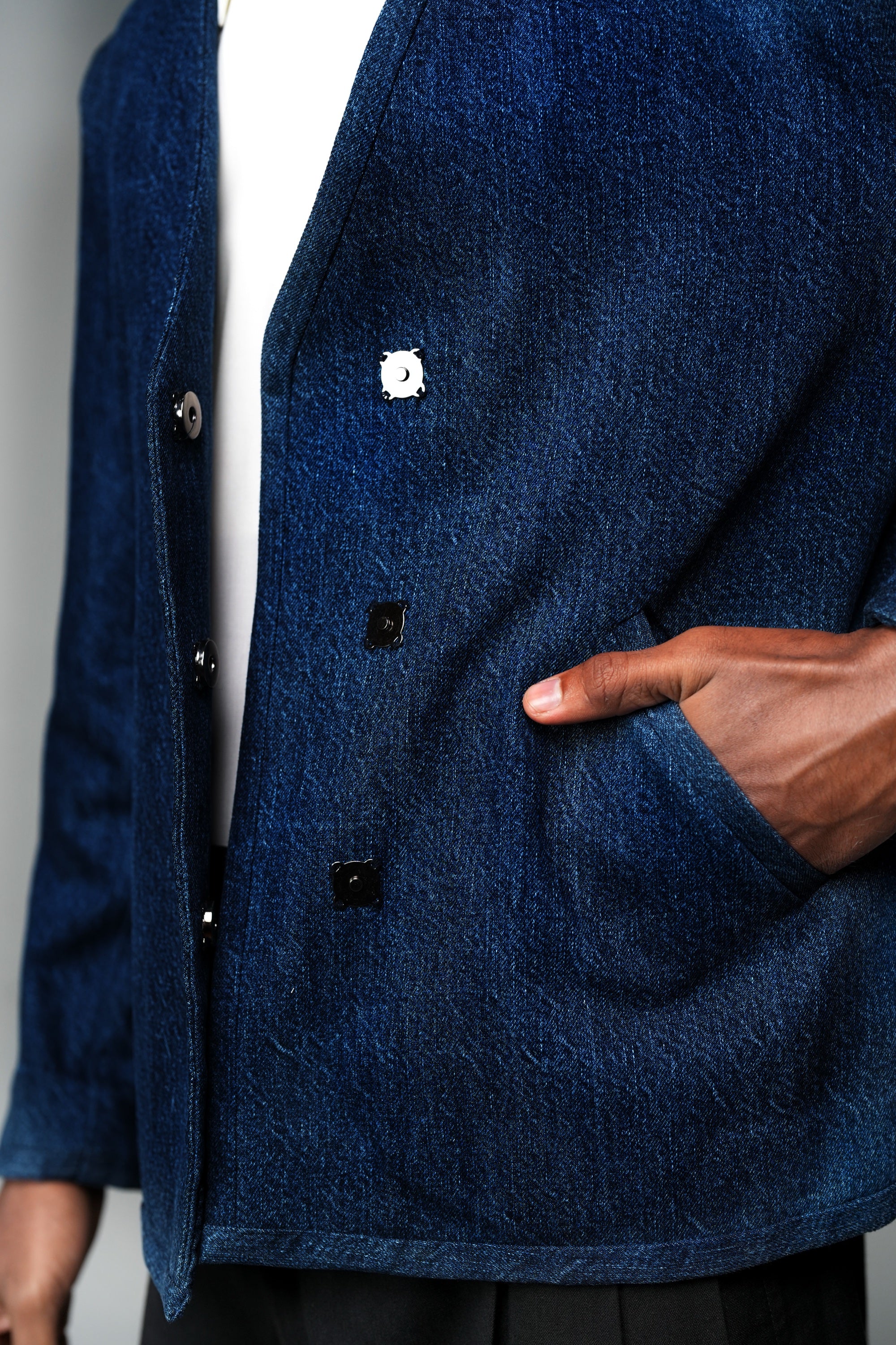 ROSANI The Core jacket in midnight denim - close-up of wrap front with magnetic snap buttons and slanted pocket, detail view