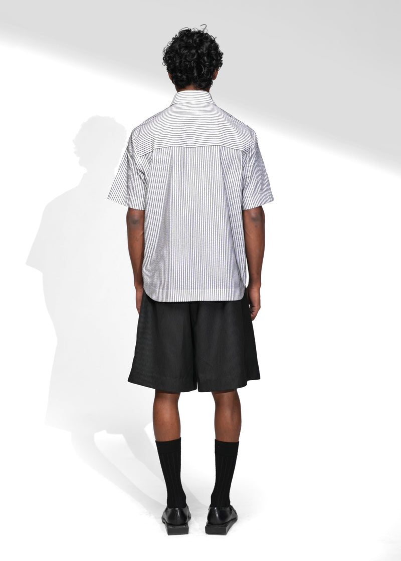 ROSANI The Frame Shirt in white, short-sleeve button-up with subtle pinstripes, styled with black tailored shorts, back view