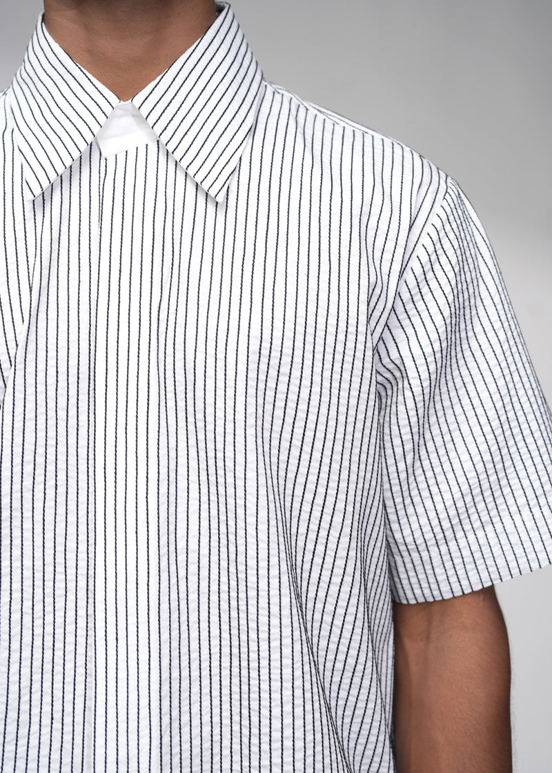 ROSANI The Frame Shirt in white, short-sleeve button-up with subtle pinstripes, styled with black tailored shorts, detail view