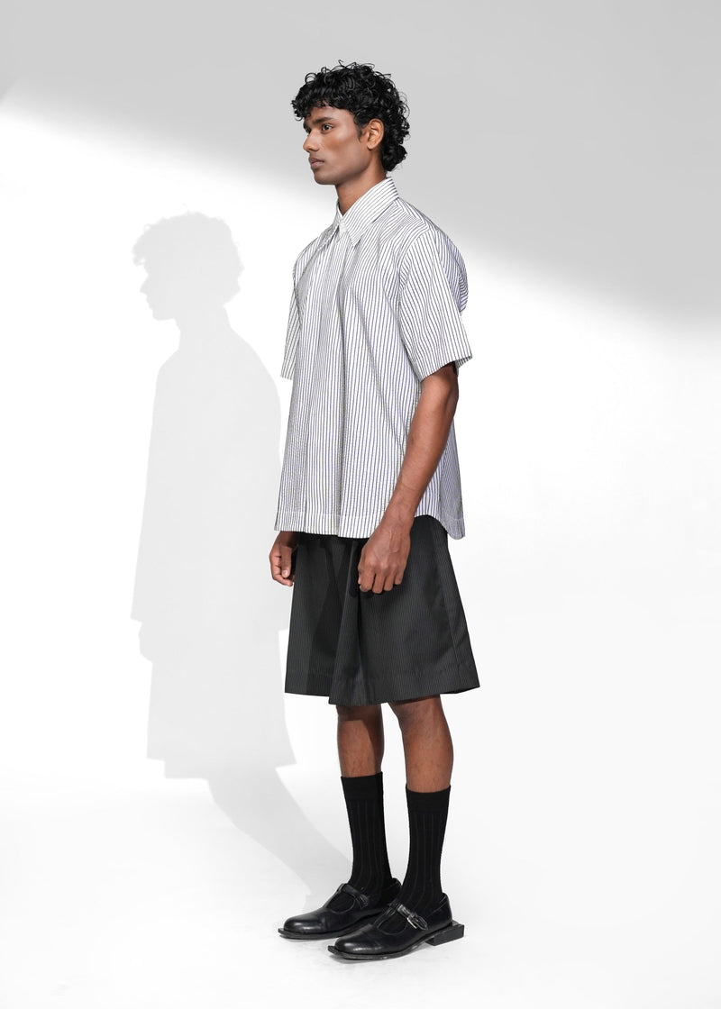 ROSANI The Frame Shirt in white, short-sleeve button-up with subtle pinstripes, styled with black tailored shorts, front side view