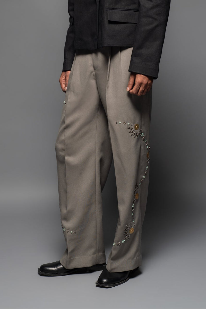 ROSANI The Kichka trouser in stone grey - wide-leg tailored trousers with floral thorn-inspired embellishment along the leg and elastic back waistband, front view, styled with a black blazer