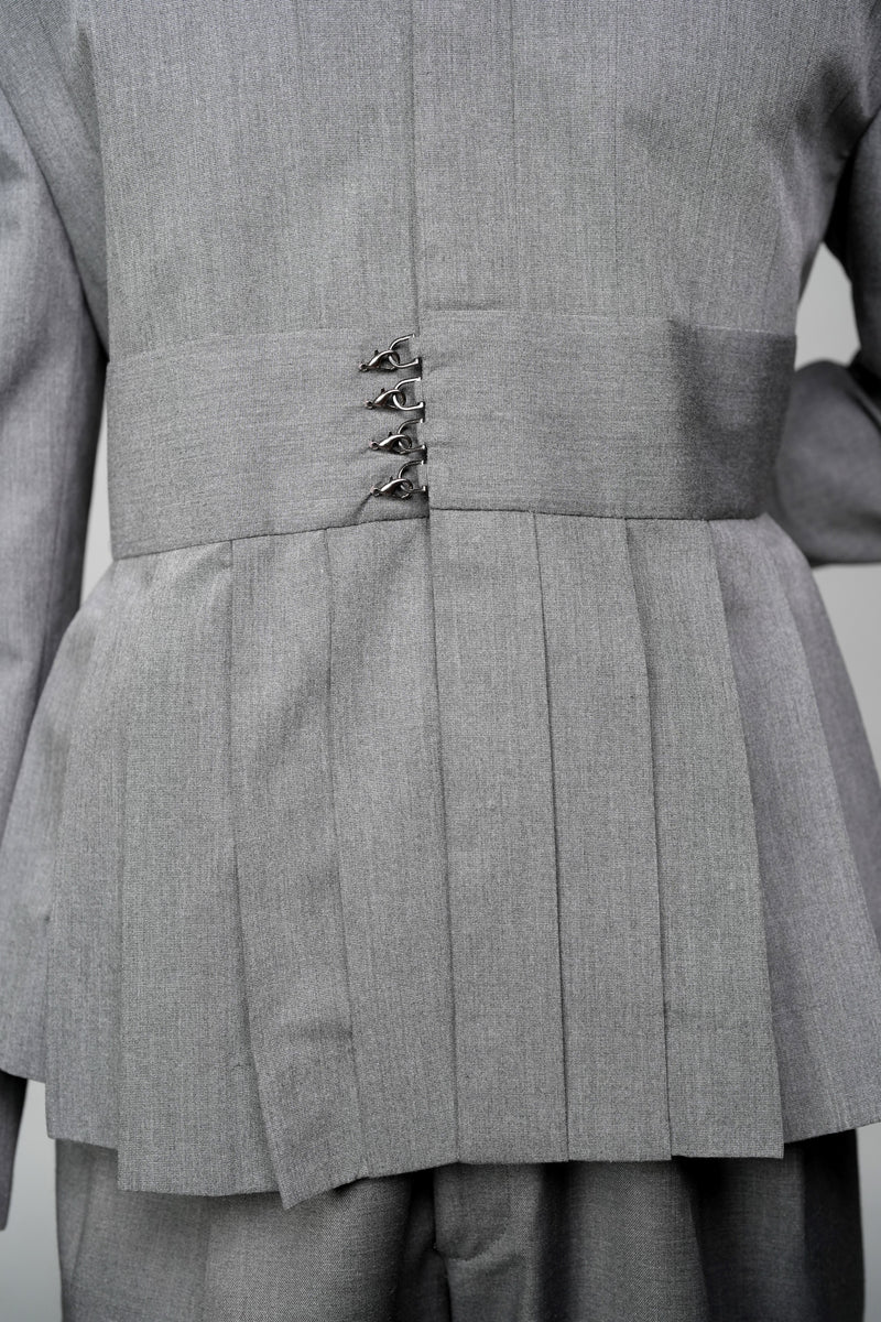 ROSANI The Sanctum jacket in grey - structured tailored jacket with sculpted peplum hem and sharp collar, detail view (styled with matching trousers)