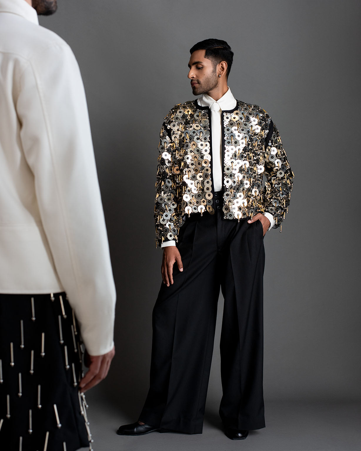 ROSANI The Jase jacket in black - heavy embellished showstopper jacket with metallic disc embroidery and hanging elements, styled with wide-leg tailored trousers, campaign image from ANIMA & ANIMUS