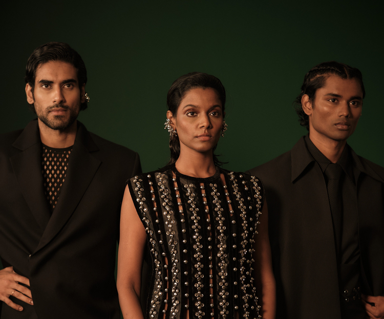ROSANI Sanctuary campaign - three models in black evening looks on a deep green backdrop, featuring sculpted tailoring and silver embellishment