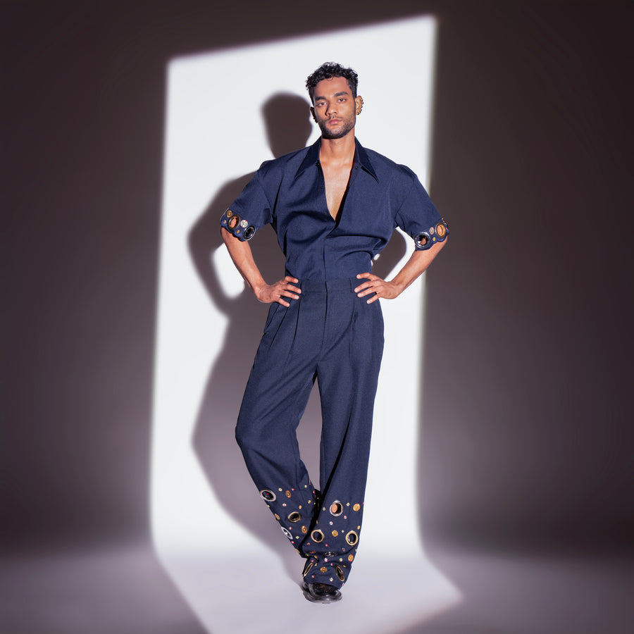 ROSANI The Alti shirt and The Aryom trouser from the DYMENSION collection. Navy co-ord with metallic ring embellishment. Full look, front view.