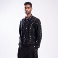 ROSANI The Arnos jacket in black, front view. Metallic eyelet embellishment and relaxed fit. DYMENSION collection.