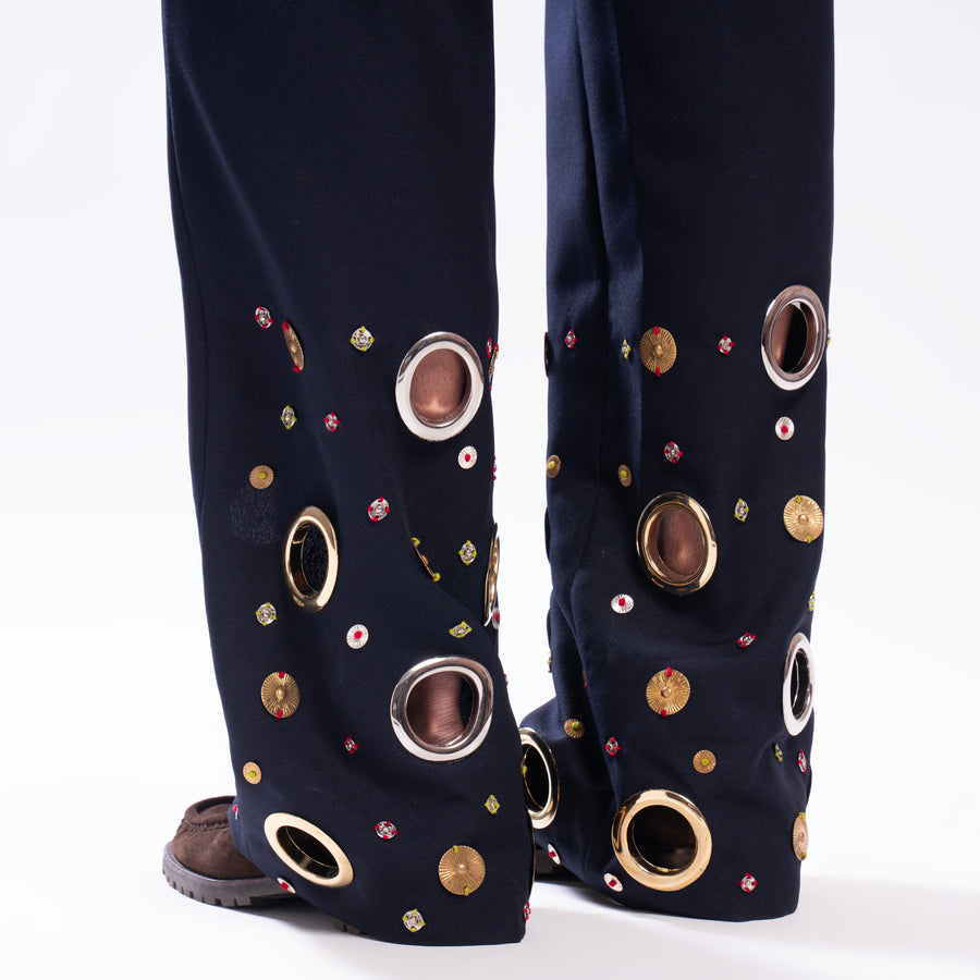ROSANI The Aryom trouser in blue, detail view of metallic ring embellishment.