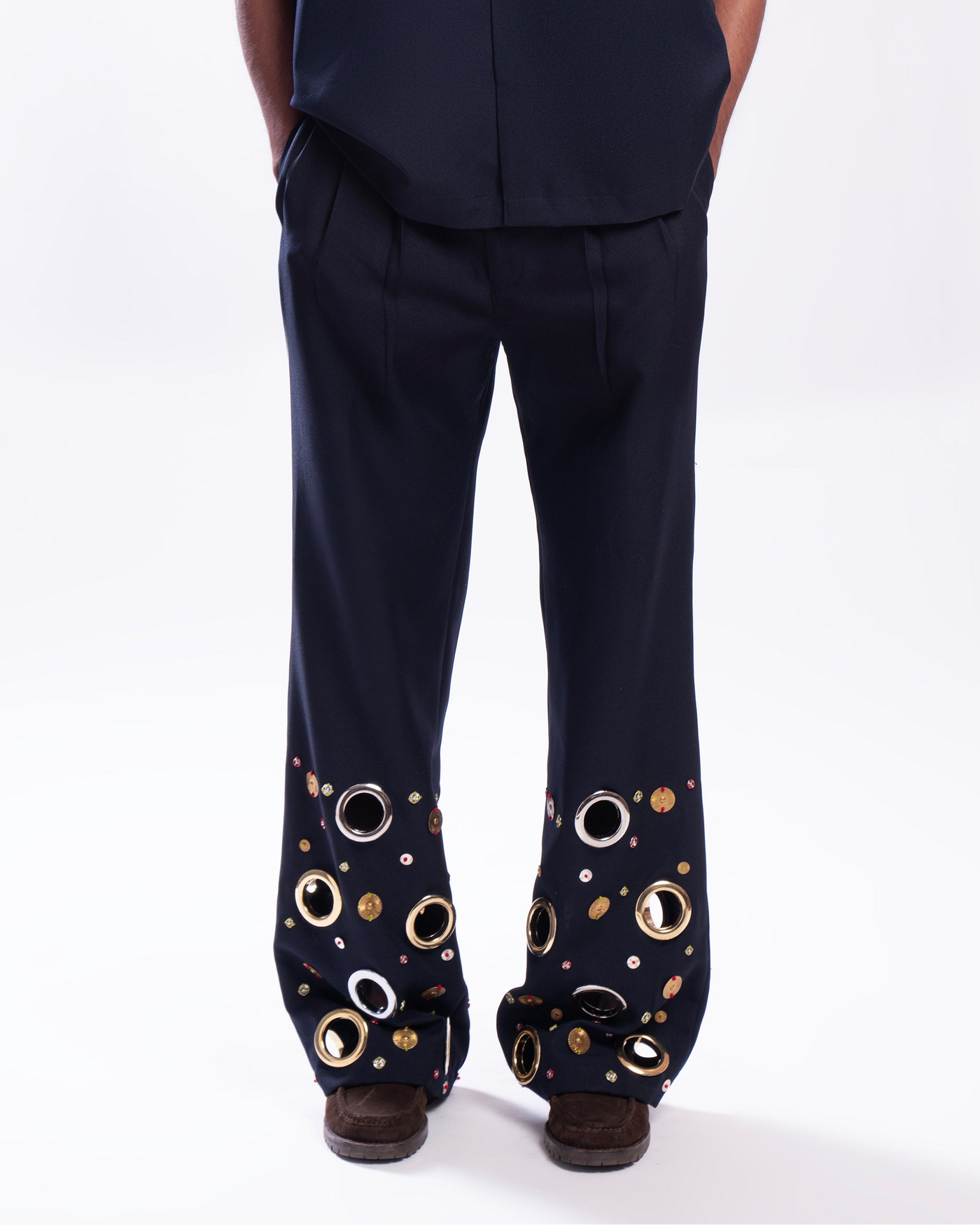 ROSANI The Aryom trouser in blue, front view. Wide-leg with metallic ring embellishment. DYMENSION collection.