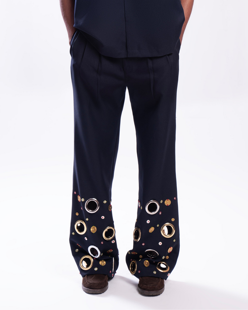 ROSANI The Aryom trouser in blue, front view. Wide-leg with metallic ring embellishment. DYMENSION collection.