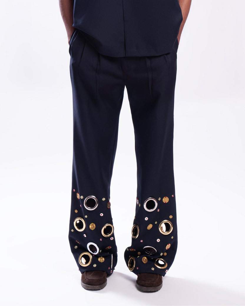 ROSANI The Aryom trouser in blue, front view. Wide-leg with metallic ring embellishment. DYMENSION collection.