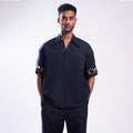 ROSANI The Alti shirt in navy. Box-fit short-sleeve with concealed placket and metallic ring sleeve accents. Front view.