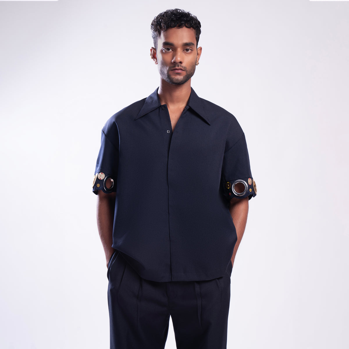 ROSANI The Alti shirt in navy. Box-fit short-sleeve with concealed placket and metallic ring sleeve accents. Front view.