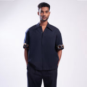 ROSANI The Alti shirt in navy. Box-fit short-sleeve with concealed placket and metallic ring sleeve accents. Front view.