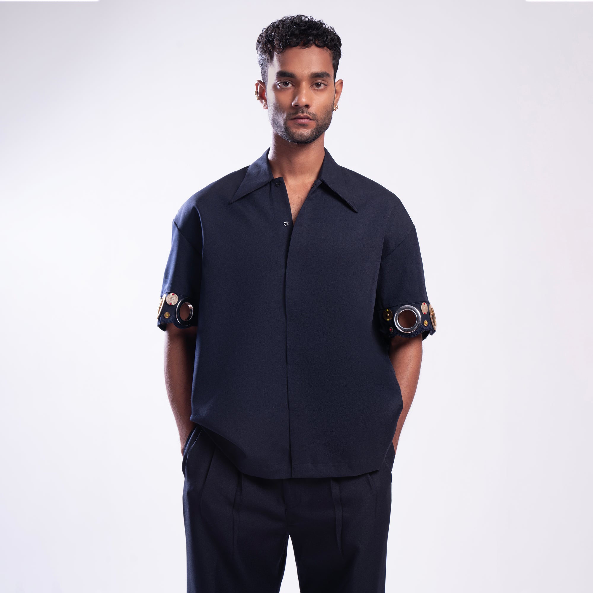 ROSANI The Alti shirt in navy. Box-fit short-sleeve with concealed placket and metallic ring sleeve accents. Front view.