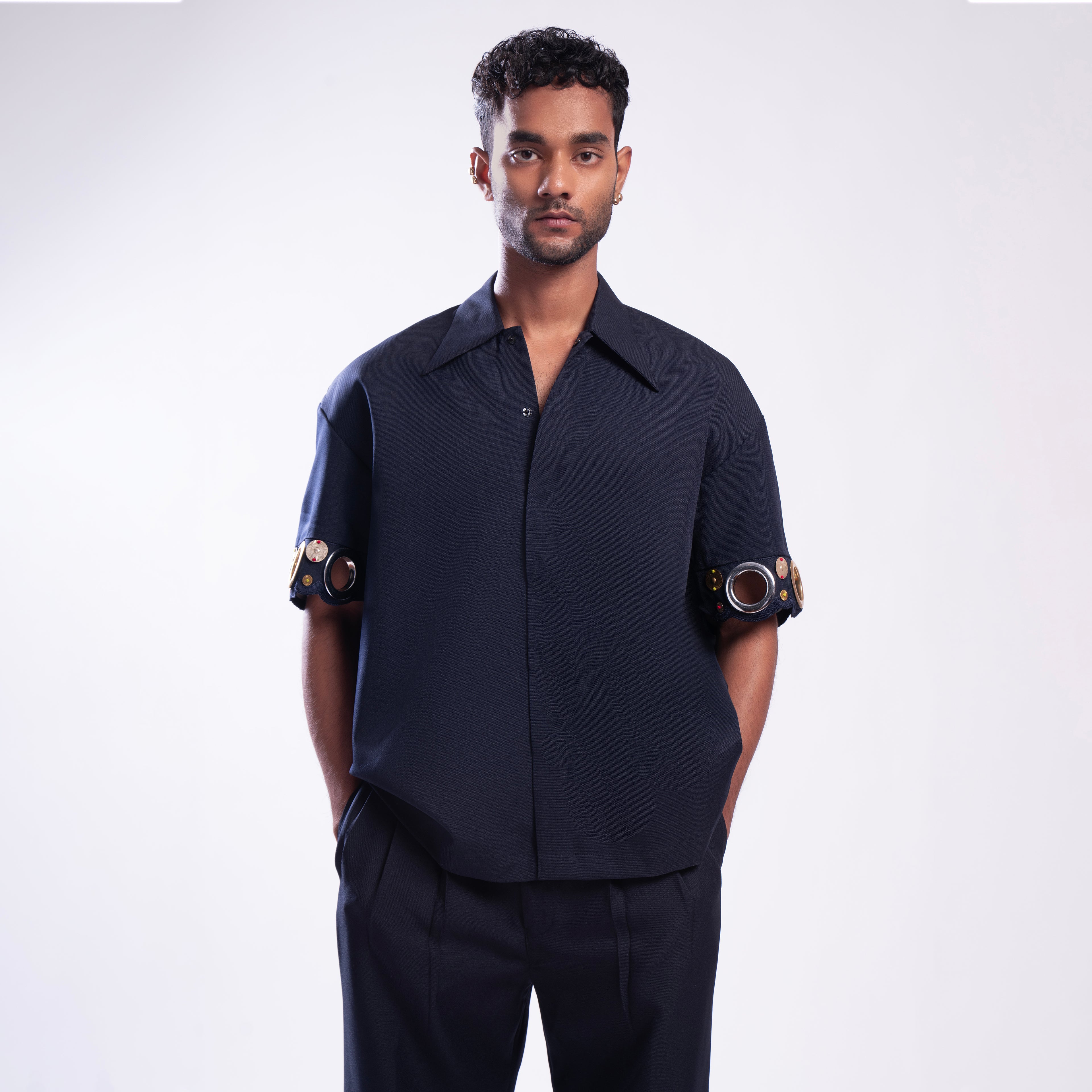 ROSANI The Alti shirt in navy. Box-fit short-sleeve with concealed placket and metallic ring sleeve accents. Front view.