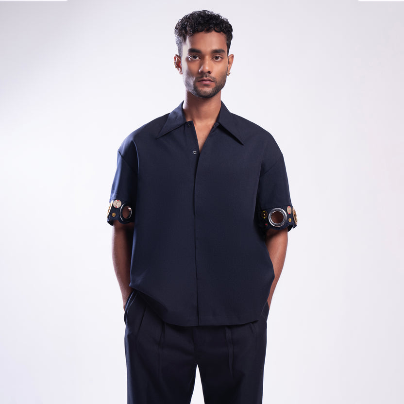 ROSANI The Alti shirt in navy. Box-fit short-sleeve with concealed placket and metallic ring sleeve accents. Front view.