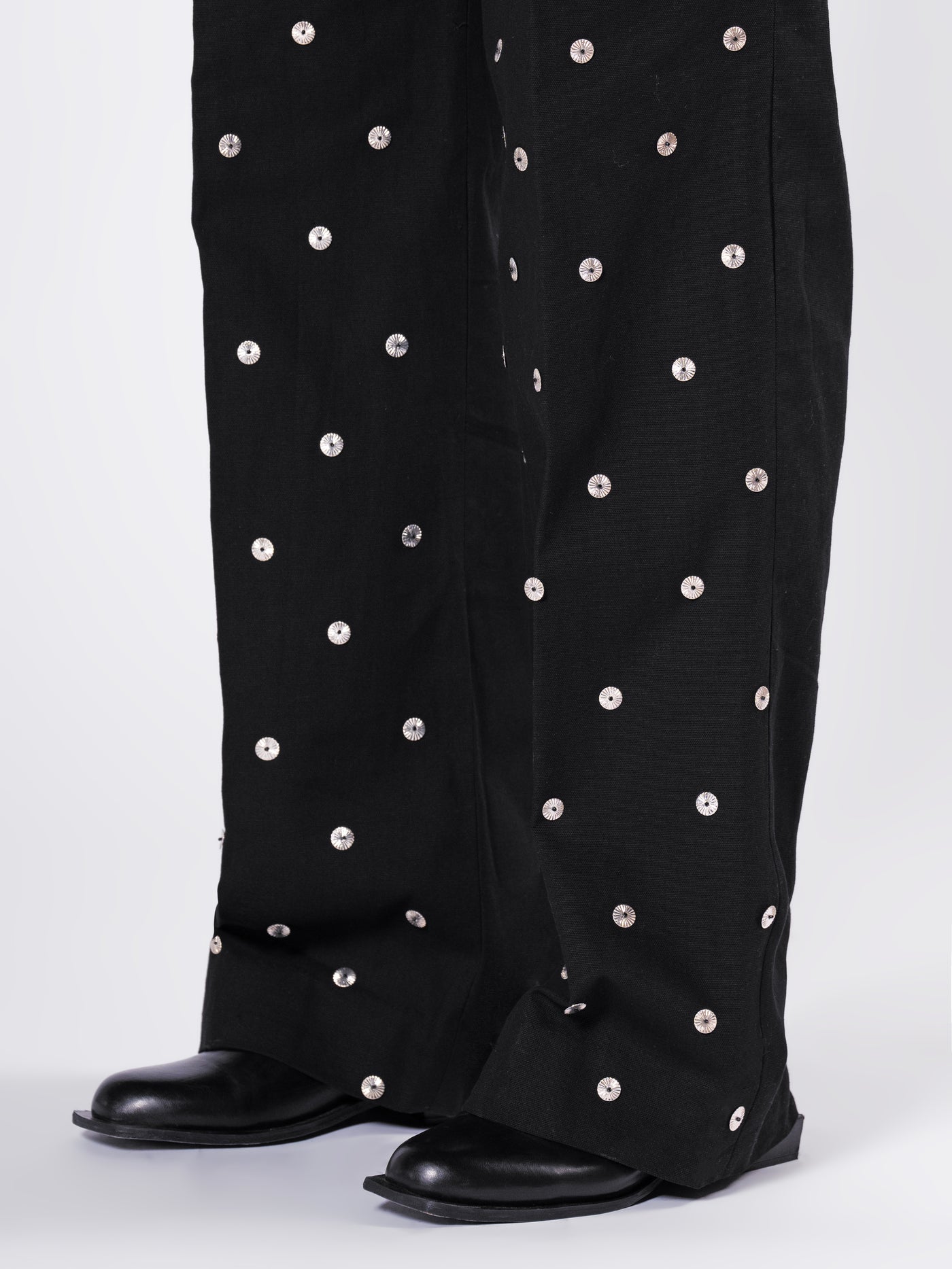 ROSANI The Blythe trouser in black. Close-up of scattered metallic disc detail on front panel.