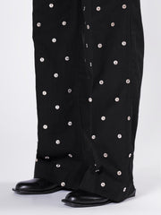 ROSANI The Blythe trouser in black. Close-up of scattered metallic disc detail on front panel.