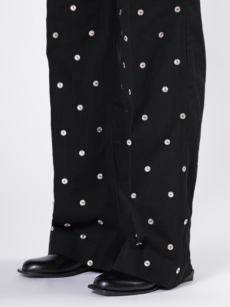 ROSANI The Blythe trouser in black. Close-up of scattered metallic disc detail on front panel.