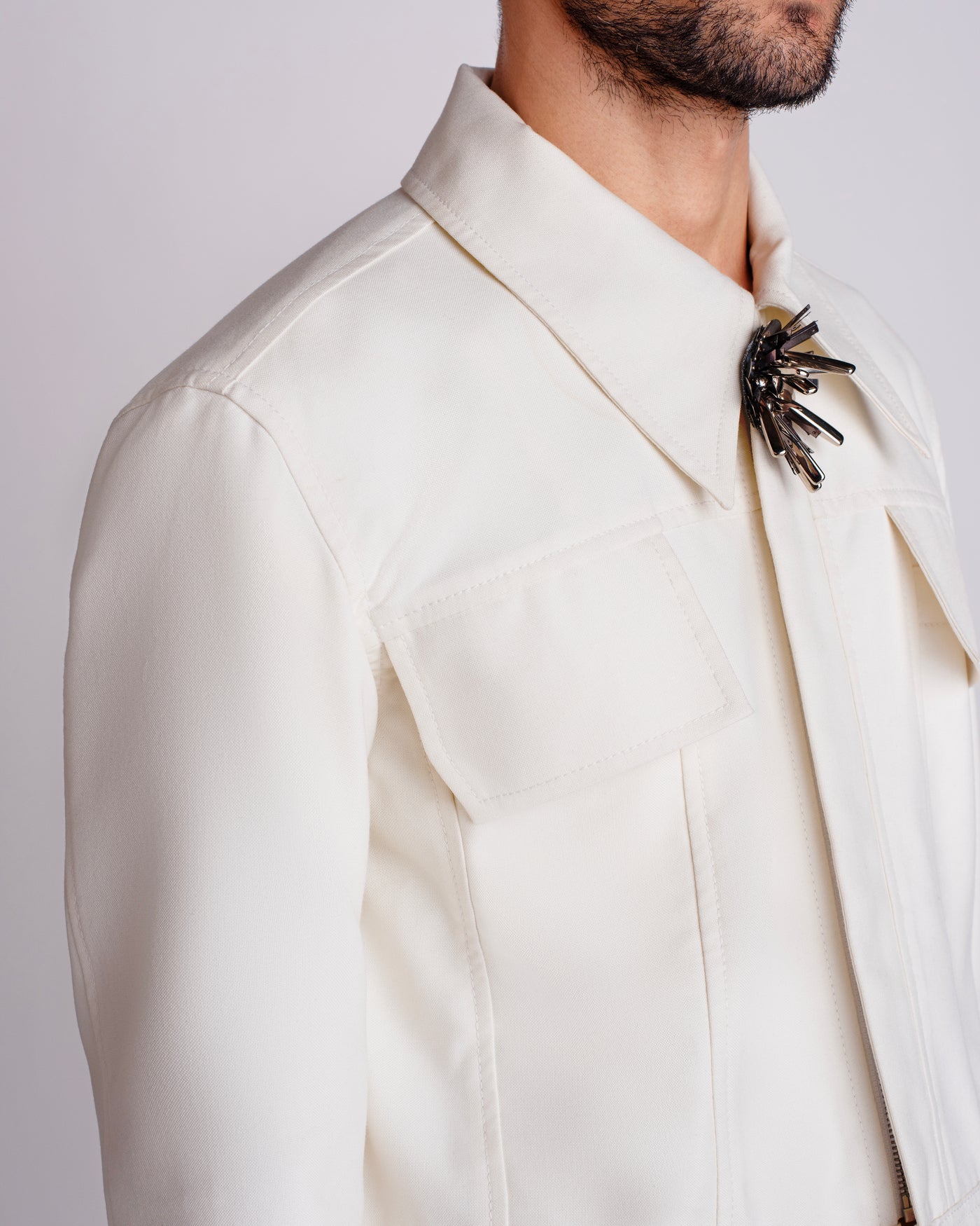 ROSANI The Charlie jacket in white. Close-up of flap pocket and magnetic snap button detail.