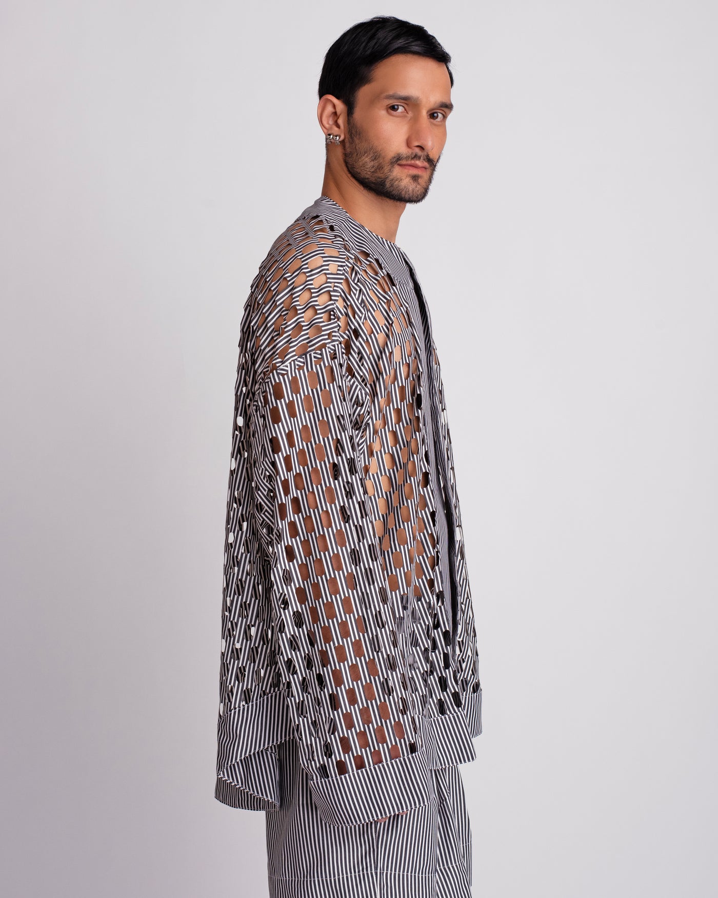 ROSANI The Emerson shirt in black and white stripes. Side view showing oversized silhouette and cut-out pattern.