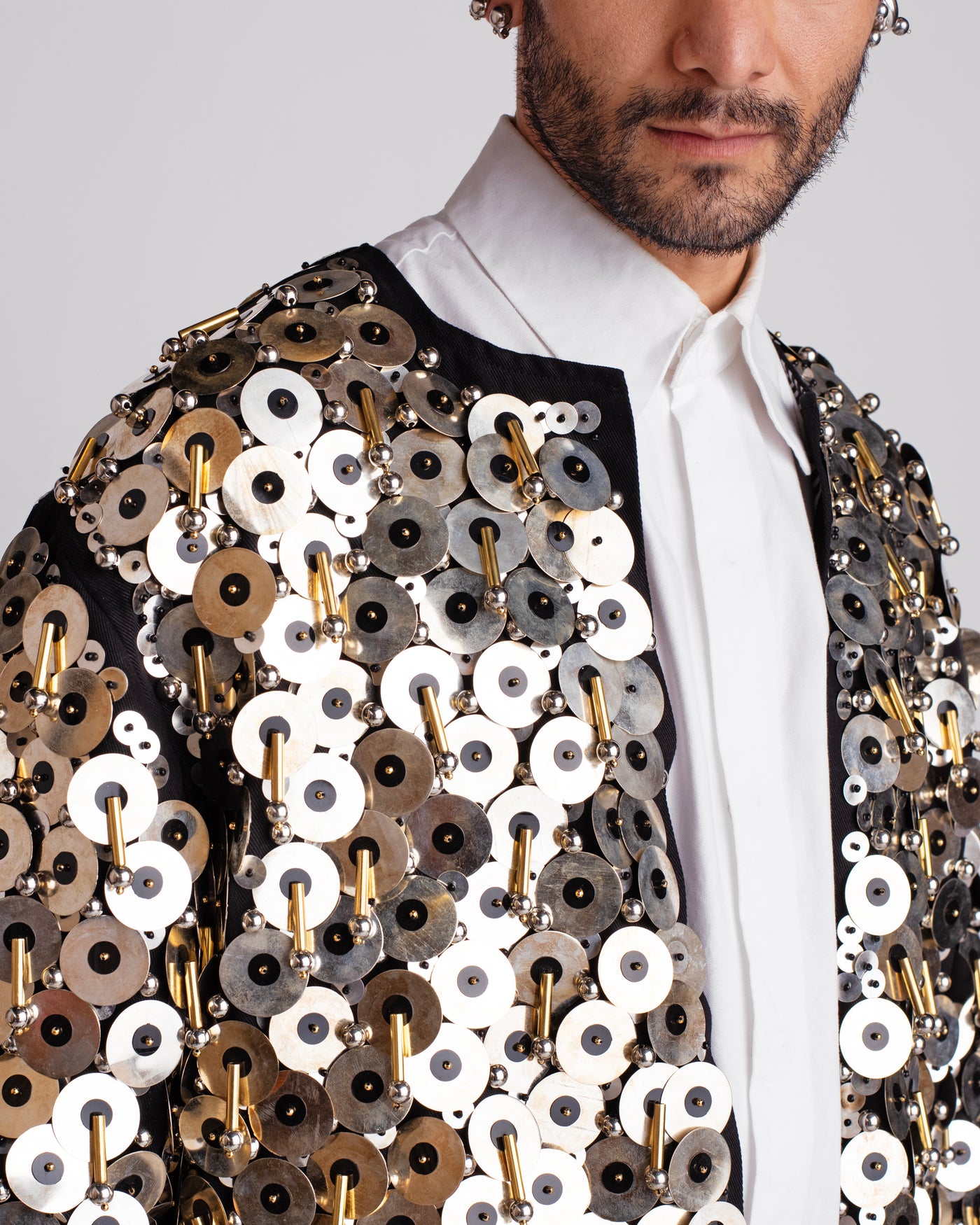 ROSANI The Jase jacket in black and silver. Close-up of metallic disc, bead and cylindrical pipe embroidery detail.