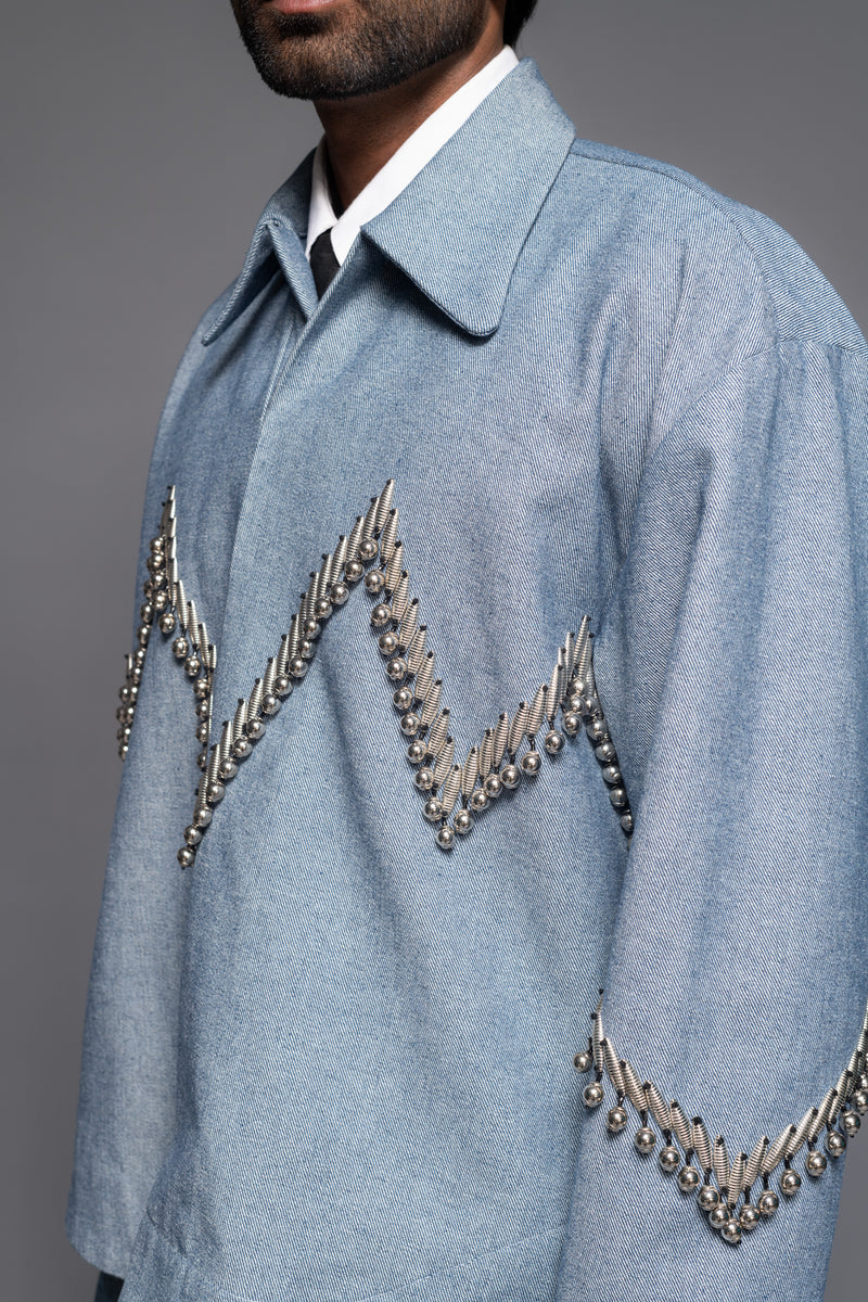 ROSANI The Munzwa jacket in denim blue - oversized unlined denim jacket with zigzag metal embellishment and front button closure, detail view