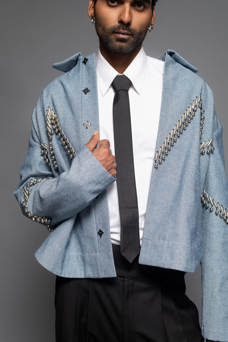 ROSANI The Munzwa jacket in denim blue - oversized unlined denim jacket with zigzag metal embellishment and front button closure, detail view