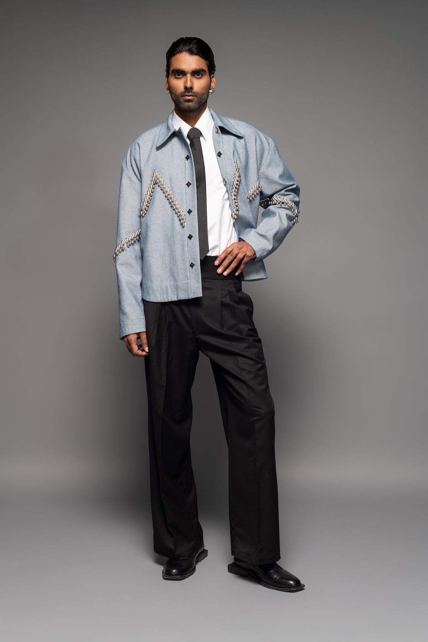 ROSANI The Munzwa jacket in denim blue - oversized unlined denim jacket with zigzag metal embellishment and front button closure, front view