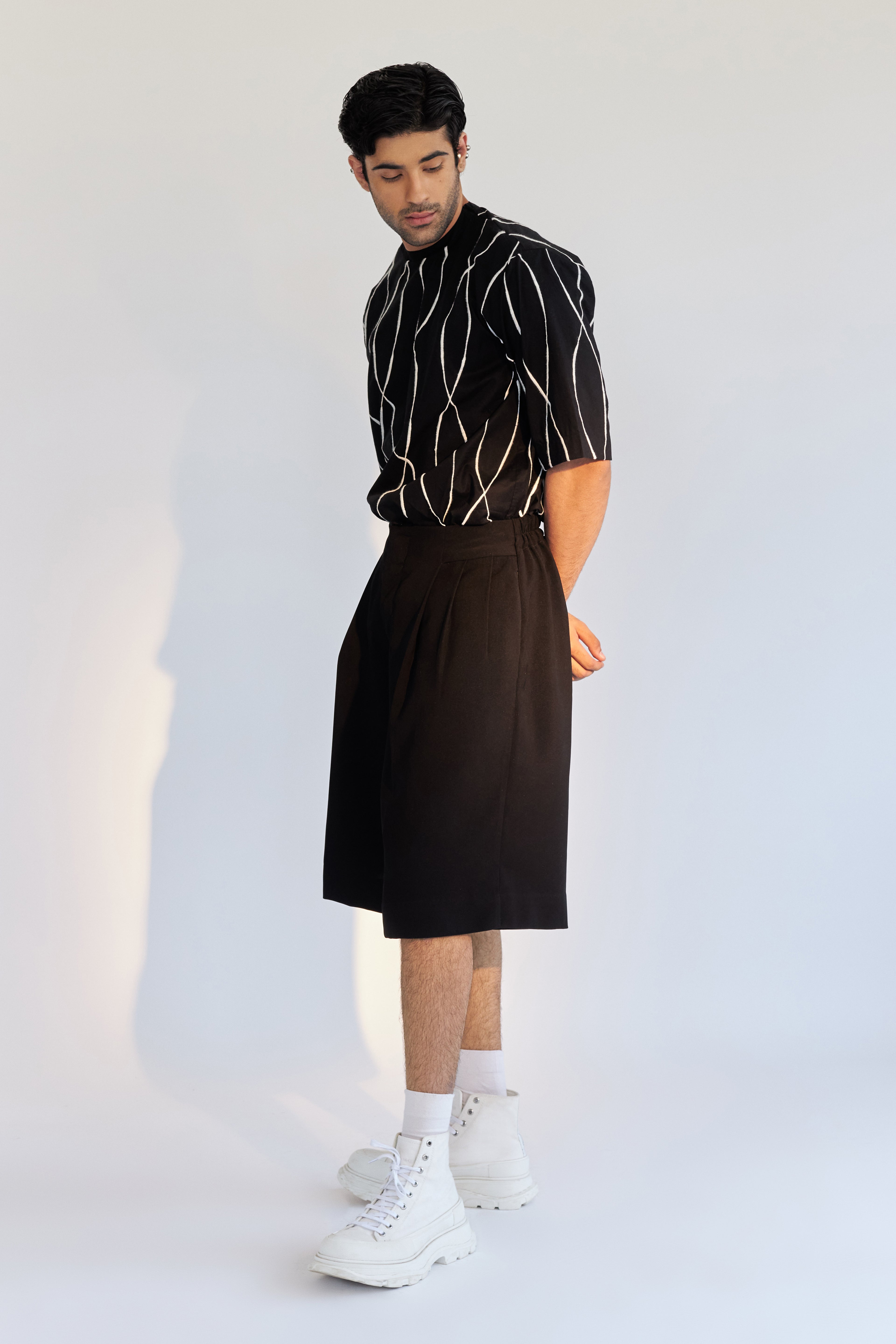 ROSANI The Le Huma short, side view. Relaxed silhouette, clean black.
